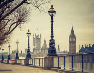 Big Ben viewed from a London embankment lined with ironwork street lamps