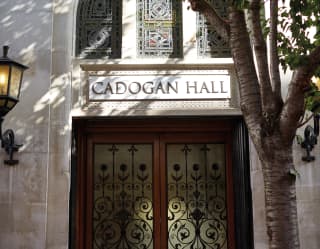Exterior of Cadogan Hall with grand wooden double doors and stained glass windows