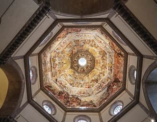 View from below of the ornate ceiling mural of the Il Duomo in Florence