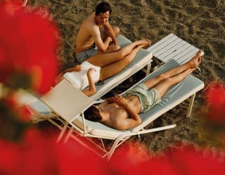 3 people relaxing on the beach sunbeds