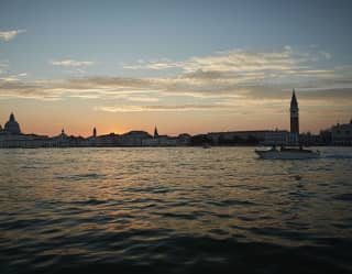 Sunset view from the Canale di San Marco towards Venice, with its silhouettes of church spires and basilica domes.