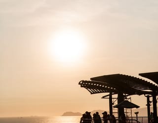 A shaded pier overlooking the Ballestas National Reserve at sunset