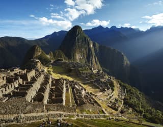 Breathtaking view over the temples and terraces of the ancient Inca citadel of Macha Picchu, nestled in a mountain cradle.