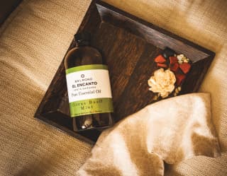 A bottle of El Encanto’s own pure citrus basil mint essential oil on a wooden tray in the hotel spa