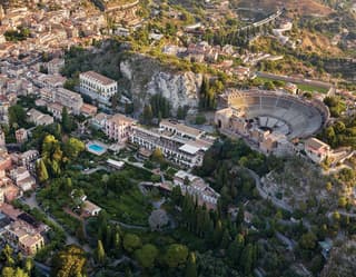 Aerial shot of Taormina with views of an ancient Greek theatre and grand residences