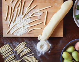 Close-up of small pasta noodles being handmade in a cookery school kitchen
