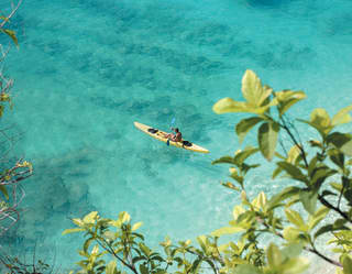 Aerial view of a lone kayaker in crystal clear waters