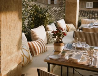 Rosy sun lights a corner of the terrace where tables and benches provide a luxurious spot to soak up the village ambience.