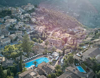 Bright pockets of blue mark the hotel's pools among Deia's limestone walls and olive groves in this birds' eye valley view