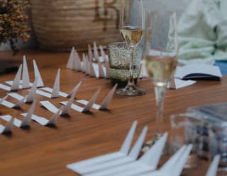 Two glasses of champagne rest on a table with a bag and a multitude of paper strips at a workshop with Viti Vici parfumiers.