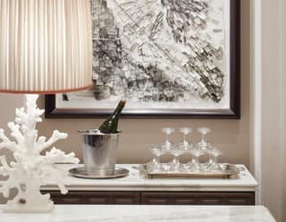 Champagne in a cooler next to a pyramid of coupe glasses