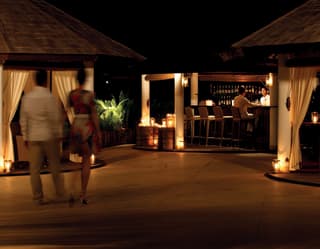 A couple approaching an elegant bar hut at night