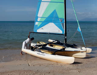 Preparing a hobbie cat sailing boat at the water’s edge for a guest’s watersports session
