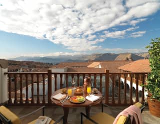 A breakfast table on the balcony overlooking cuso city