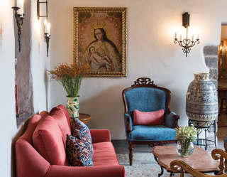 Hotel reception with 16th century artwork, elegant furnishings and a ceramic pot