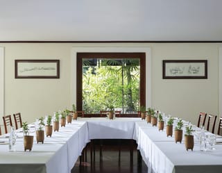 U-shaped banquet tables in a light and airy room set for a meeting
