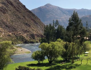 Manicured hotel gardens alongside the Urubamba River in a mountainous valley
