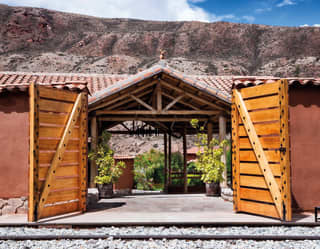 Two barn doors opening to a train platform with a terracotta tiled roof