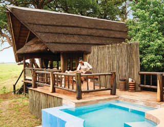 Spa therapist massaging a guest on an outdoor spa terrace overlooking grasslands