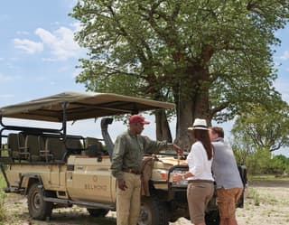 At a stop on the safari, a local guide tells guests about wildlife