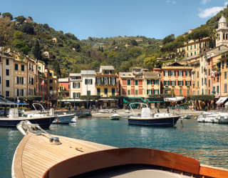 View of Portofino harbour from inside a gozzo boat, other boats bob nearby