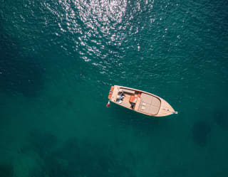 From above, deep bluegreen water surrounds a gozzo boat