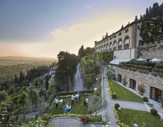 Aerial view of guests celebrating in stunning hilltop gardens at sunset