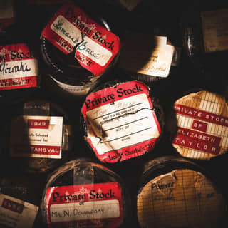 Vintage wine bottles stacked upon each other with old labels