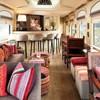 Elegant train bar car with imprinted leather chairs and vibrant Peruvian fabrics