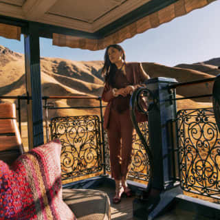 A woman in a brown suit standing on the open-air observation deck