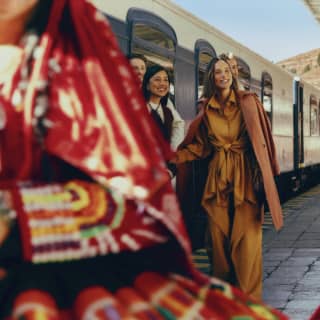 Passengers alighting at Cusco train station are met by dancers wearing bright, traditional Peruvian clothing.