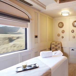 Bright train spa carriage with a massage table next to a large picture window