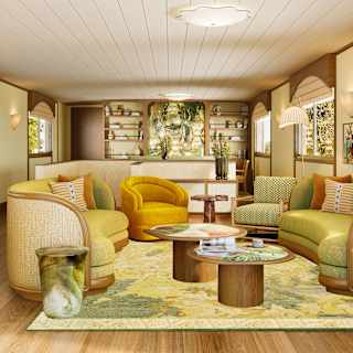 Two curved green sofas, yellow tub chair, lounge chair and coffee tables create a cosy living area in a chic, bright space.