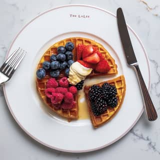 Birds eye view of a circular waffle topped with berries and bananas