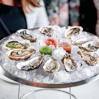 Close-up of oysters on a bed of ice in a circular sliver dish