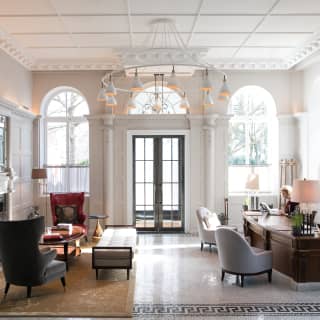 Elegant regency-style double-height guest lobby with contemporary wooden desk