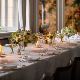 Candlelight among the floral displays transforms a banquet table into an intimate celebration, in a view of the Lillie room.