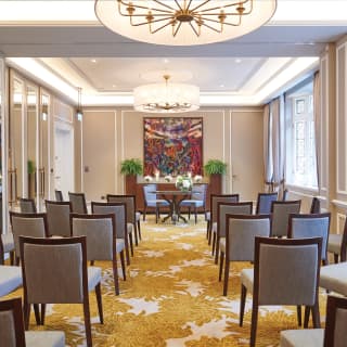 Large elegant room with yellow patterned carpet and chairs in rows of three