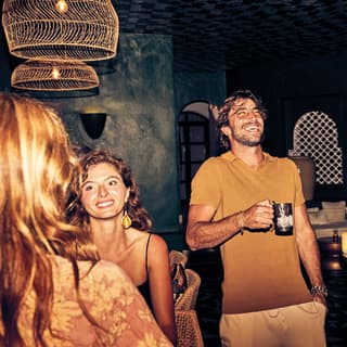 Stylish guests laughing and talking in a bar at night