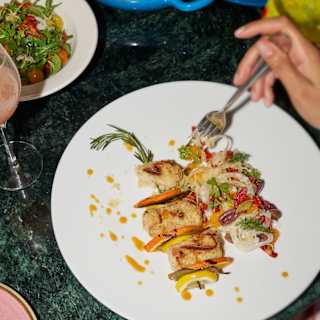 Looking down on a dish of Pesce Spada Siciliana, with breaded swordfish, fennel, oranges and olives, at Cip’s by Cipriani.