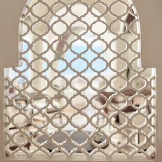A Moorish geometric pattern hints at privacy as it fills an arched window with a white lattice grille