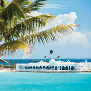 On the peninsula between Cove Bay and Maundays Bay the arches of The Cap Juluca Hotel are pure white against blue seas