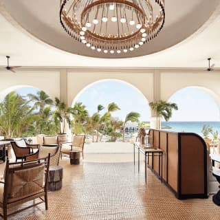 Hotel guest lobby area with archways and modern circular chandelier