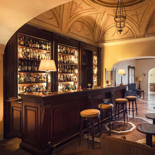 Elegant bar at Caruso with a domed room and polished mahogany bar counter and shelves