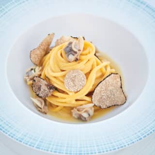 Generous slices of truffles and clams adorn a spiralled linguine peak of handmade fresh pasta