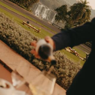 The hotel lawns reach towards the incredible cascading Iguassu Falls, while champagne is poured in soft-focus foreground.