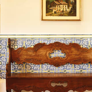 A public area of the hotel showing traditional blue-and-white ceramic wall tiles and traditional carved wooden bench