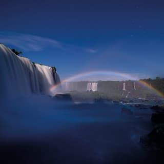 An evening rainbow caused by moonlight in the spray above the cascades of Iguassu Falls