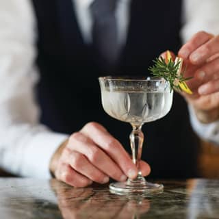 Close-up of a champagne cocktail garnished with lemon in an ornate coupe glass