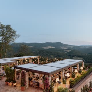 Aerial view of Cip's Restaurant, magical at dusk as guests dine beneath pergolas lit with fairy lights and warm-glow lamps.